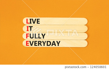 LIFE live it fully everyday symbol. Concept word LIFE Live It Fully Everyday on beautiful sticks. Beautiful orange background. Business motivational LIFE live it fully everyday concept. Copy space. LIFE live it fully everyday symbol. Concept word LIFE Live It Fully Everyday on beautiful sticks. Beautiful orange background. Business motivational LIFE live it fully everyday concept. Copy space. 124058601