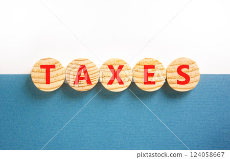 Taxes symbol. Concept word Taxes on beautiful wooden circles. Beautiful white and blue background. Business lifestyle taxes concept. Copy space. 124058667