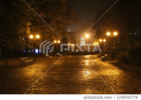 View of night park with burning lanterns. City park at night. Night city park View of night park with burning lanterns. City park at night. Night city park 124058779