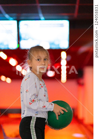 Young girl child having fun and playing bowling Young girl child having fun and playing bowling 124058831