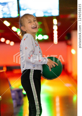 Young girl child having fun and playing bowling Young girl child having fun and playing bowling 124058835