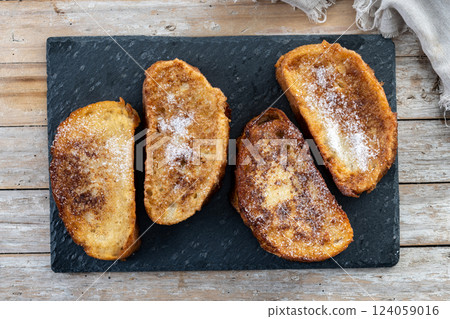 Traditional Spanish torrijas for Holy Week on wooden tableq 124059016