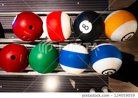 vibrant bowling ball in colorful, well-lit bowling alley with various balls and blurred background creating dynamic atmosphere vibrant bowling ball in colorful, well-lit bowling alley with various balls and blurred background creating dynamic atmosphere 124059059