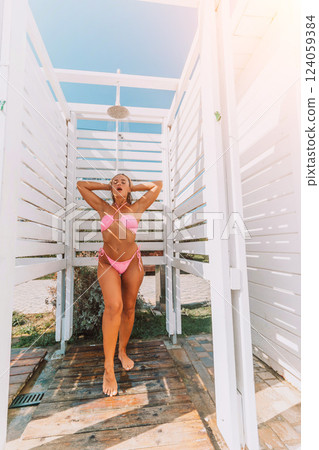 Beach Shower Woman Summer: Outdoor Beach Shower, Woman in Pink Bikini Rinsing After Sunbathing, Refreshing Summer Hygiene. Beach Shower Woman Summer: Outdoor Beach Shower, Woman in Pink Bikini Rinsing After Sunbathing, Refreshing Summer Hygiene. 124059384