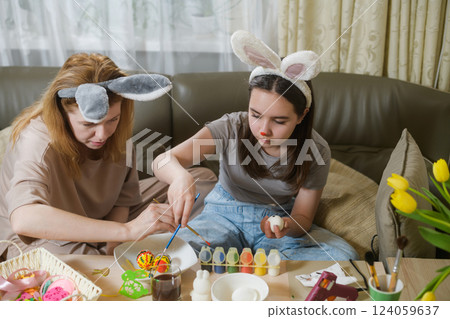 Mother And Daughter Painting Easter Eggs Together. Mother And Daughter Painting Easter Eggs Together. 124059637