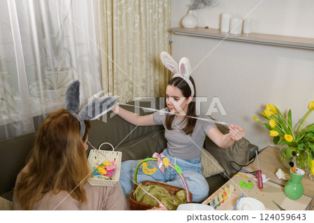 Mother and daughter preparing Easter decorations together. 124059643