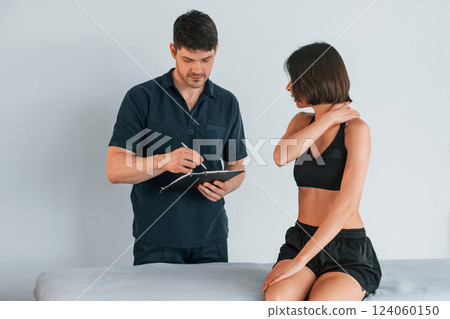 Sitting on the table. Woman visiting physiologist that making massages and helping with traumas 124060150