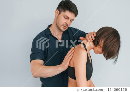 Working with spine and neck. Woman visiting physiologist that making massages and helping with traumas 124060156