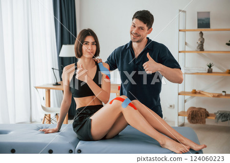Finished result. Woman visiting physiologist that putting kinesio tape on the skin Finished result. Woman visiting physiologist that putting kinesio tape on the skin 124060223