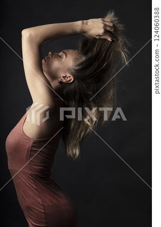 portrait of a young beautiful woman on a dark background 124060388