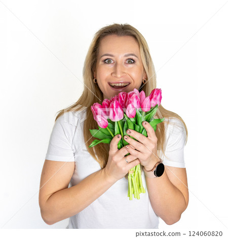 European blonde mature woman with Spring Flower Tulips pink bouquet. Happy surprised model woman smelling flowers. Mother's Day. Springtime 124060820