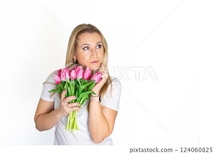 European blonde mature woman with Spring Flower Tulips pink bouquet. Happy surprised model woman smelling flowers. Mother's Day. Springtime 124060825