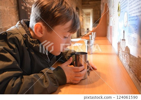 A boy in a tactile museum smells odors. The concept of free inclusive art for children and adults A boy in a tactile museum smells odors. The concept of free inclusive art for children and adults 124061590