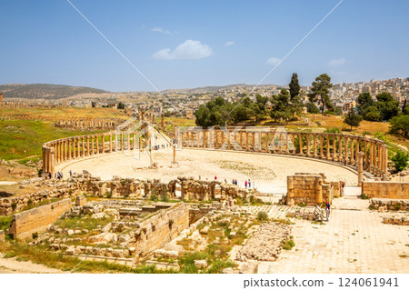 Ancient Roman forum square with ruins, pillars and modern arab city in the background, Jerash, Jordan 124061941