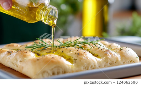 Freshly baked focaccia drizzled with olive oil and garnished with rosemary. 124062590