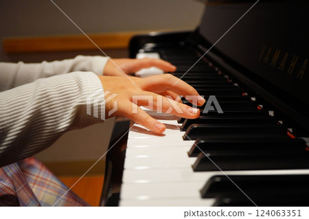 一名 11 歲的五年級小學生正在彈奏直立式鋼琴。 一名 11 歲的五年級小學生正在彈奏直立式鋼琴。 124063351