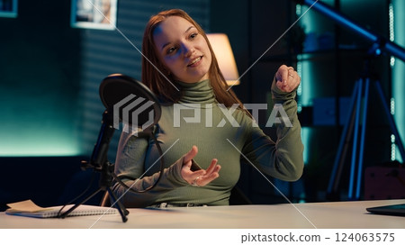 Social media star uses professional gear to capture welcoming intro for vlogging channel, interacting with online community. Influencer connects with loyal fanbase during live stream 124063575