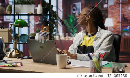 Fatigued woman daydreaming, gazing outside the window, feeling bored after working too much on job tasks. Contemplative person at home caught in thoughts, pondering, camera B Fatigued woman daydreaming, gazing outside the window, feeling bored after working too much on job tasks. Contemplative person at home caught in thoughts, pondering, camera B 124063588