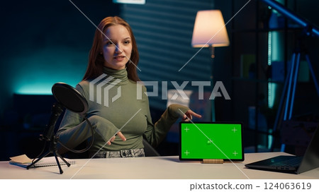 Smiling teenager presenting followers green screen mockup tablet, doing influencer marketing. Media star showcasing chroma key device, fulfilling brand advertising contract, camera A 124063619