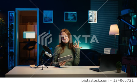 Gen Z media star filming video about best bluetooth music playing devices of the year. Happy young tech content creator recording portable speaker review, evaluating audio quality, camera B 124063721