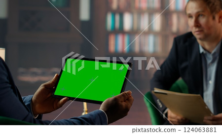Team of skilled agents engaging in a strategic meeting with chroma key screen, emphasizing professionalism and discretion in a government mission. CIA staff gathering data. Camera B. 124063881