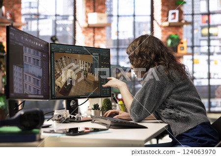 Designer interacts with digital technology to produce a virtual home set. The architectural software enables 3D modeling and rendering, allowing placement of furniture and layout adjustments. Designer interacts with digital technology to produce a virtual home set. The architectural software enables 3D modeling and rendering, allowing placement of furniture and layout adjustments. 124063970