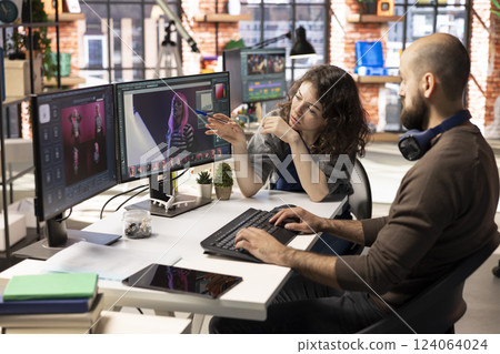 Man and woman creative team using AI to generate image models, operating an editing software to enhance digital materials and create quality content. AI assistant with photo retouching. 124064024