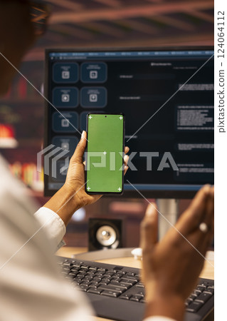 Woman sending vocal commands to AI LLM chatbot on PC using isolated screen smartphone. Close up of person speaking in mockup phone to communicate with artificial intelligence chatbot on computer 124064112