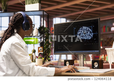 Programmer wearing headphones using computer at home for artificial intelligence computing simulating human brain. IT professional listening music and working with AI deep neural networks at home 124064118