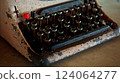 Antique cast iron typewriter with mechanical keyboard stands on wooden table 124064277