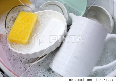Dishes and bowls in water and bubbles of dishwashing liquid. Kitchen work Dishes and bowls in water and bubbles of dishwashing liquid. Kitchen work 124064745