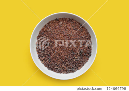Black himalayan salt in white bowl on yellow background. Black himalayan salt in white bowl on yellow background. 124064796