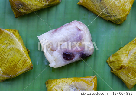 Bundled boiled sticky rice with banana and black beans wrapped in banana leaves Bundled boiled sticky rice with banana and black beans wrapped in banana leaves 124064885