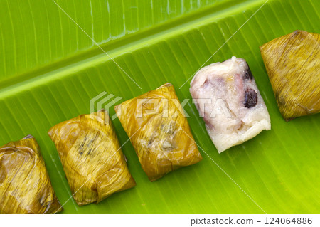 Bundled boiled sticky rice with banana and black beans wrapped in banana leaves Bundled boiled sticky rice with banana and black beans wrapped in banana leaves 124064886