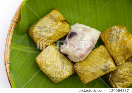 Bundled boiled sticky rice with banana and black beans wrapped in banana leaves Bundled boiled sticky rice with banana and black beans wrapped in banana leaves 124064887