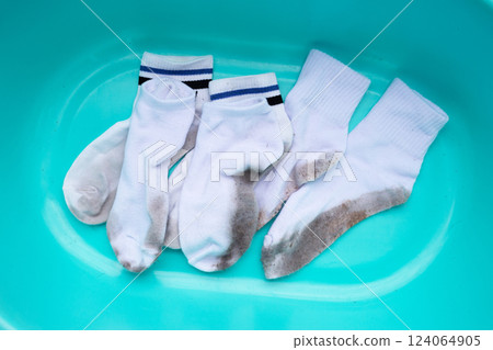 Dirty white socks in blue basin 124064905