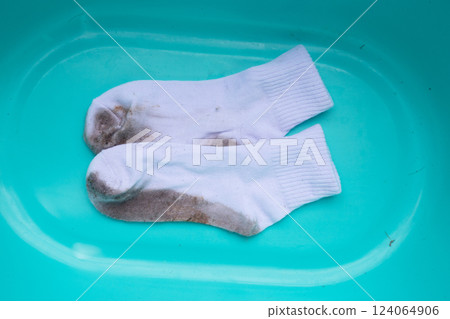 Dirty white socks in blue basin 124064906