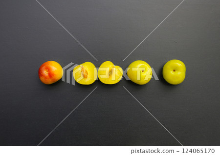 Fresh green plum fruit on dark background. Fresh green plum fruit on dark background. 124065170
