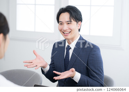 Image of a young salesman explaining something to a customer Image of a young salesman explaining something to a customer 124066064