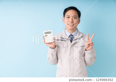 Smiling man holding a calculator, business, work clothes Smiling man holding a calculator, business, work clothes 124066302