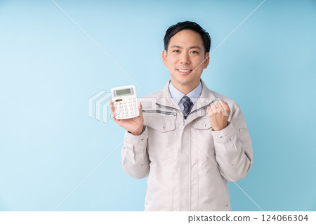 Smiling man holding a calculator, business, work clothes Smiling man holding a calculator, business, work clothes 124066304