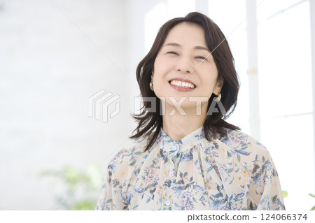 一位身穿花襯衫、微笑的中年婦女 一位身穿花襯衫、微笑的中年婦女 124066374
