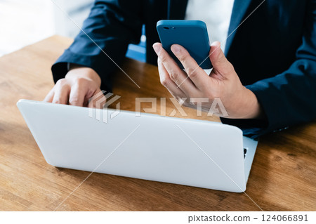 A man who operates a computer and a smartphone A man who operates a computer and a smartphone 124066891