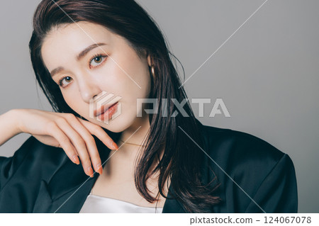 Beautiful woman wearing a jacket and applying make-up Beautiful woman wearing a jacket and applying make-up 124067078