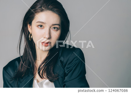 Beautiful woman wearing a jacket and applying make-up 124067086