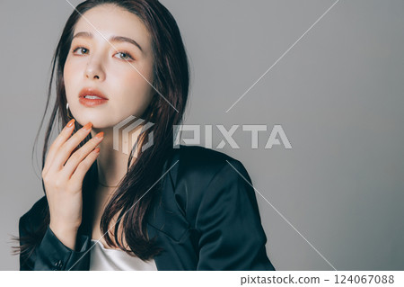 Beautiful woman wearing a jacket and applying make-up Beautiful woman wearing a jacket and applying make-up 124067088