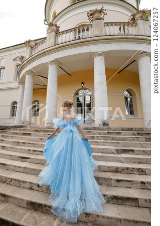 Elegant Woman in a Flowing Blue Gown Walking Down the old stone Stairs Elegant Woman in a Flowing Blue Gown Walking Down the old stone Stairs 124067257