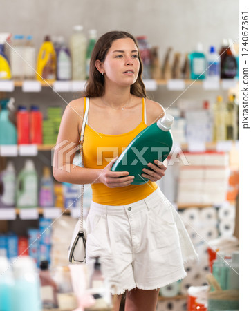 Girl consumer with household chemical products for washing indoors 124067361