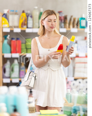 Young woman choosing repellent in supermarket 124067373
