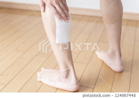 Applying a compress to the calf, compress, muscle pain, body parts Applying a compress to the calf, compress, muscle pain, body parts 124067448